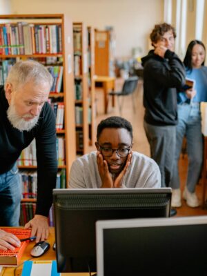 Students and a mentor collaborate in a university library, engaging in educational activities.